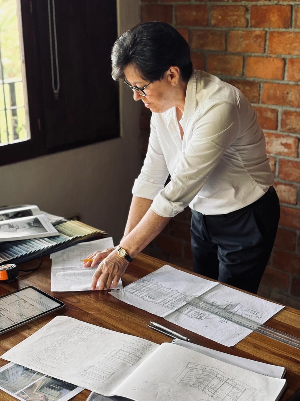A Surí designer reviewing furniture plans in the workshop