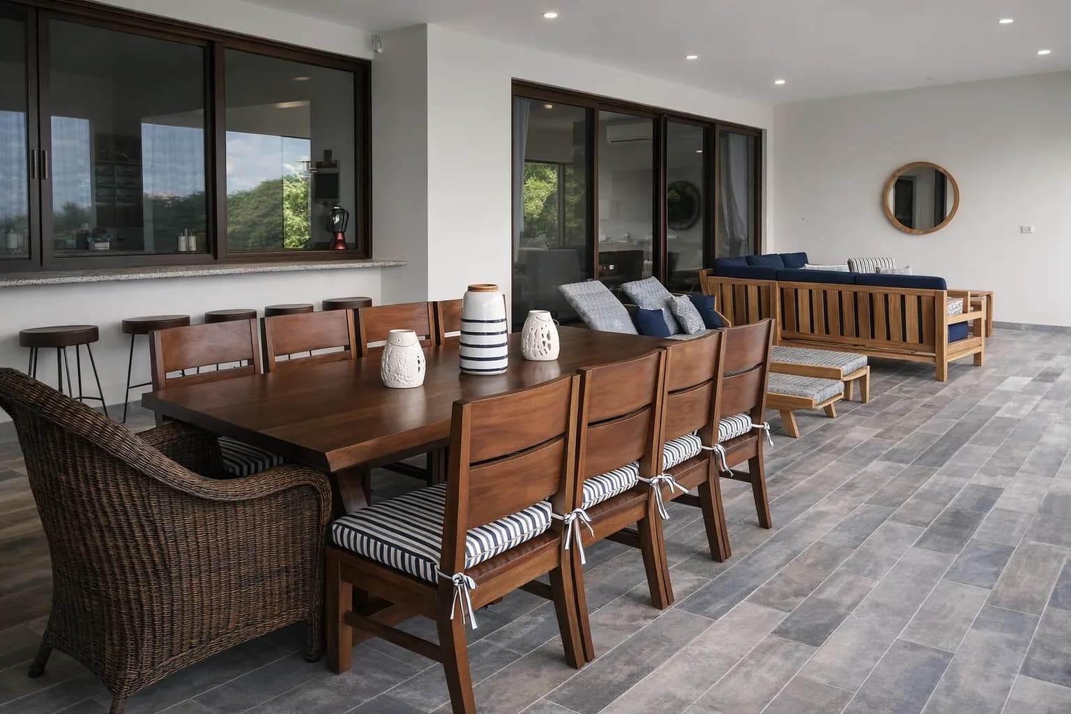 Covered terrace furnished with a long dining table and lounge seating