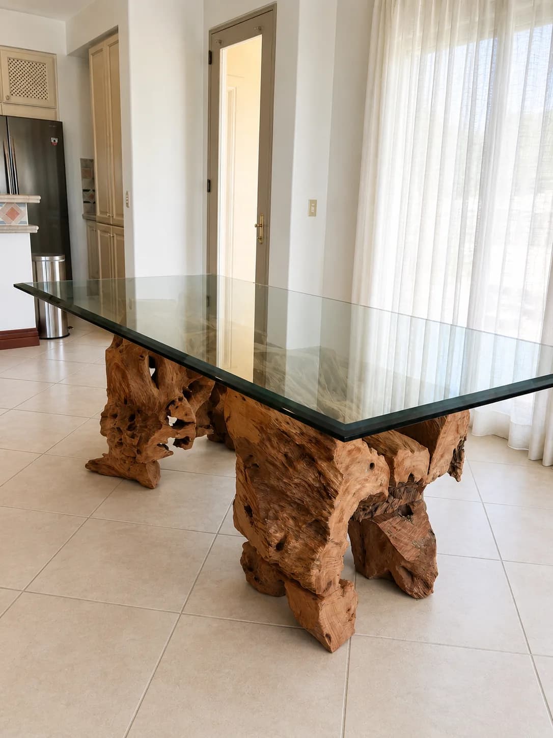 Glass table with a sculptural natural-wood base